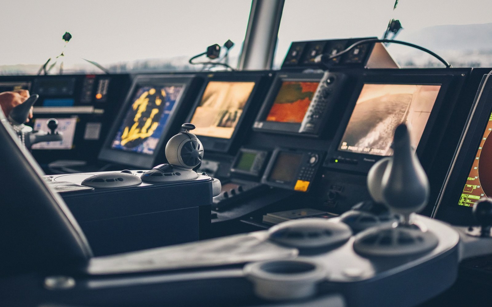 Ship's bridge control panel with radar screens, navigation displays and control levers