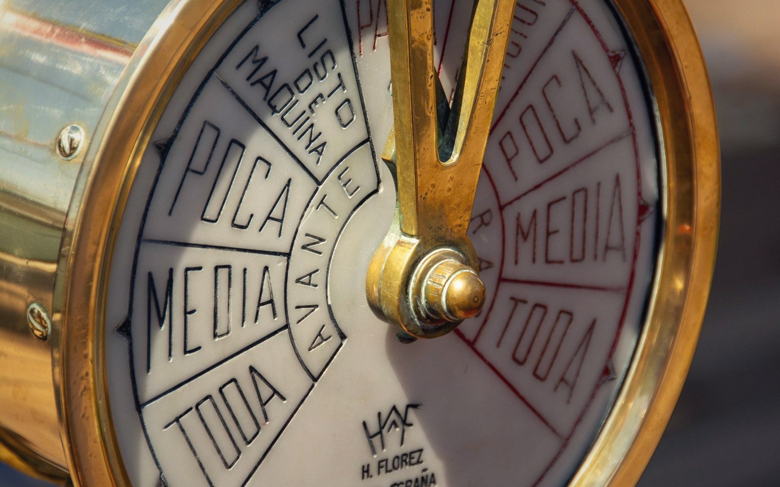 Brass ship's engine order telegraph dial with Spanish speed settings marked in black